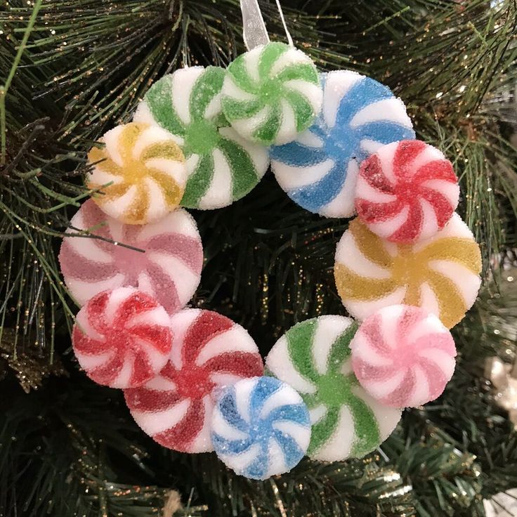 an ornament hanging from a christmas tree decorated with lollipops