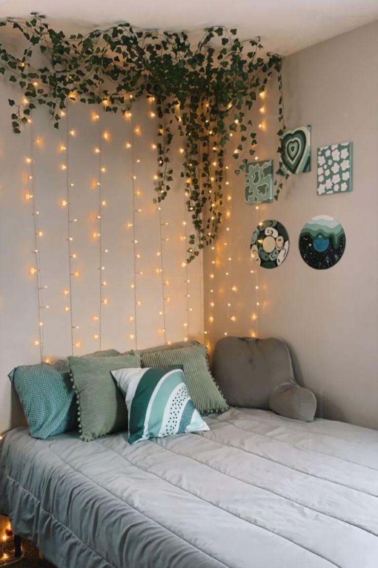 a bed sitting under a tree with lights on the wall next to it's headboard