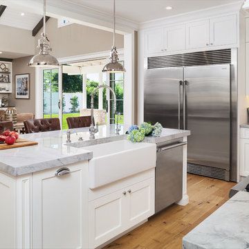 a large kitchen with an island in the middle and stainless steel appliances on both sides