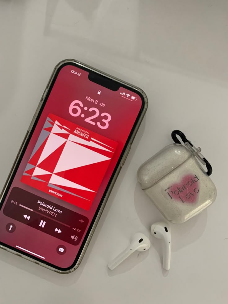 an iphone with ear buds next to it on a white counter top and a bag