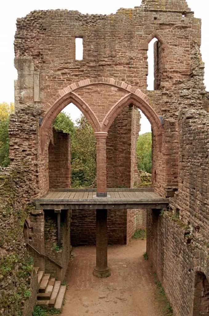 an old brick building with stairs leading up to the doorways and into the distance