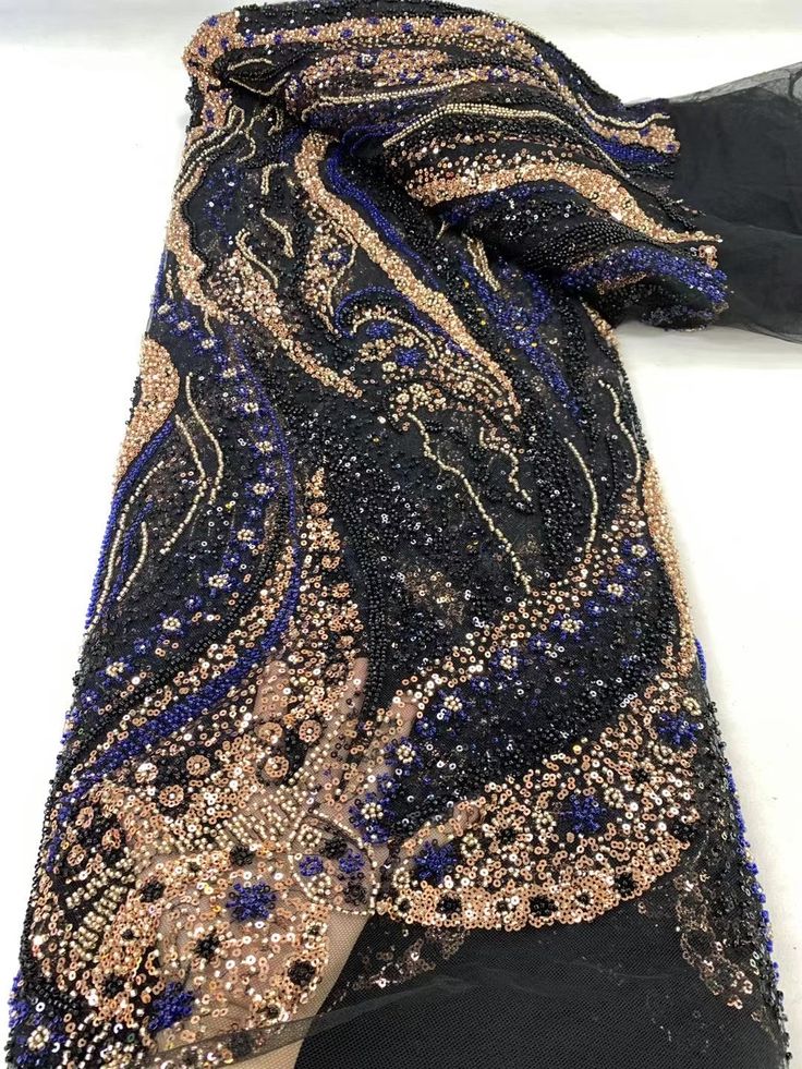 a woman's black and gold dress laying on the ground