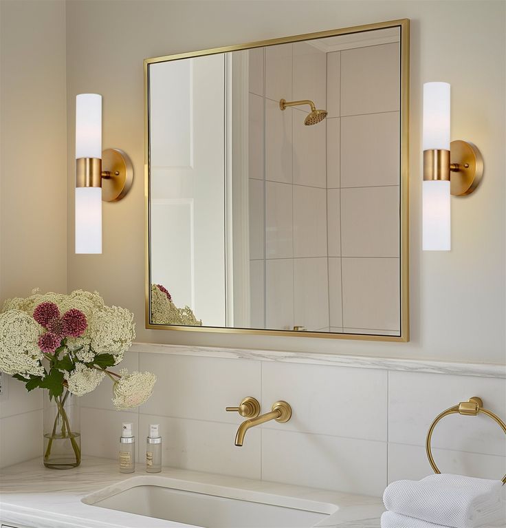 a bathroom with a sink, mirror and flowers in the vase on the counter top