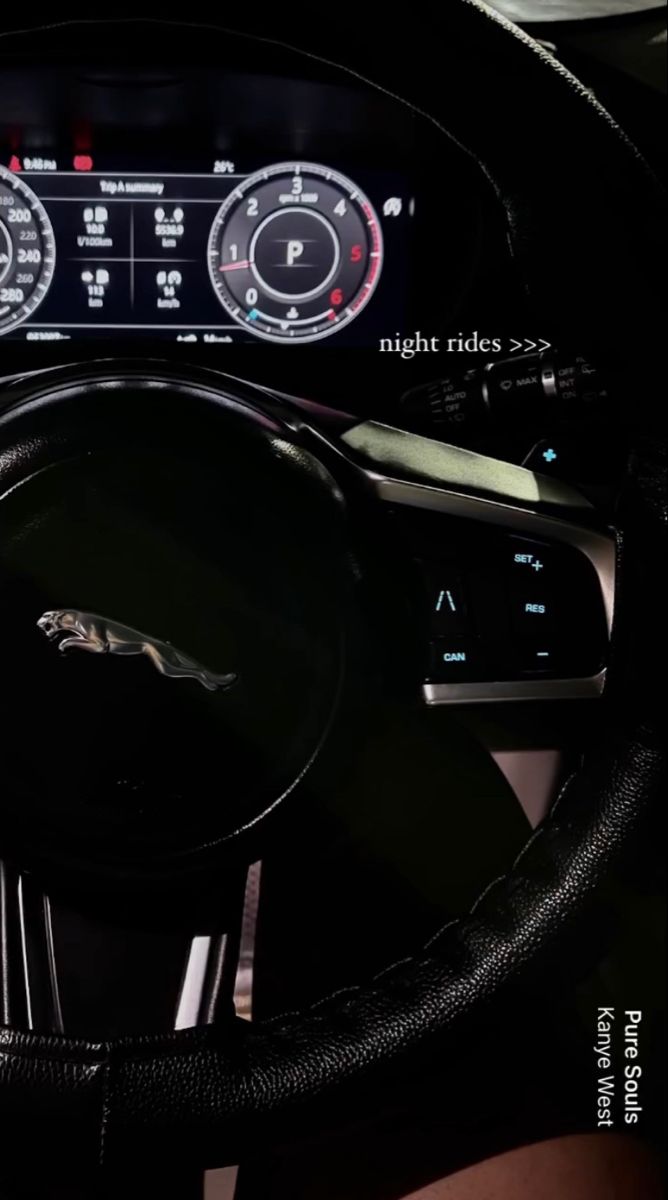 the interior of a car with steering wheel and gauges on display at night rides