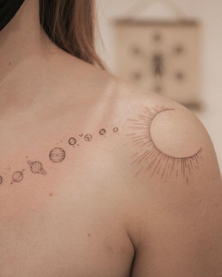 a woman's chest with the sun and planets on it