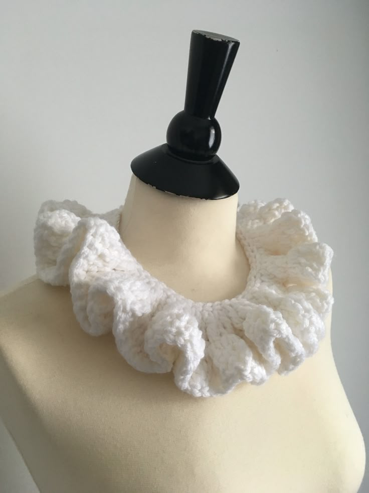 a white crocheted neck scarf on a mannequin