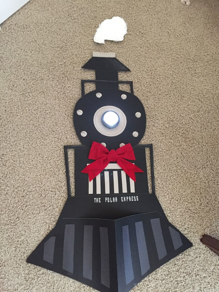 a paper cut out of a train with a red bow