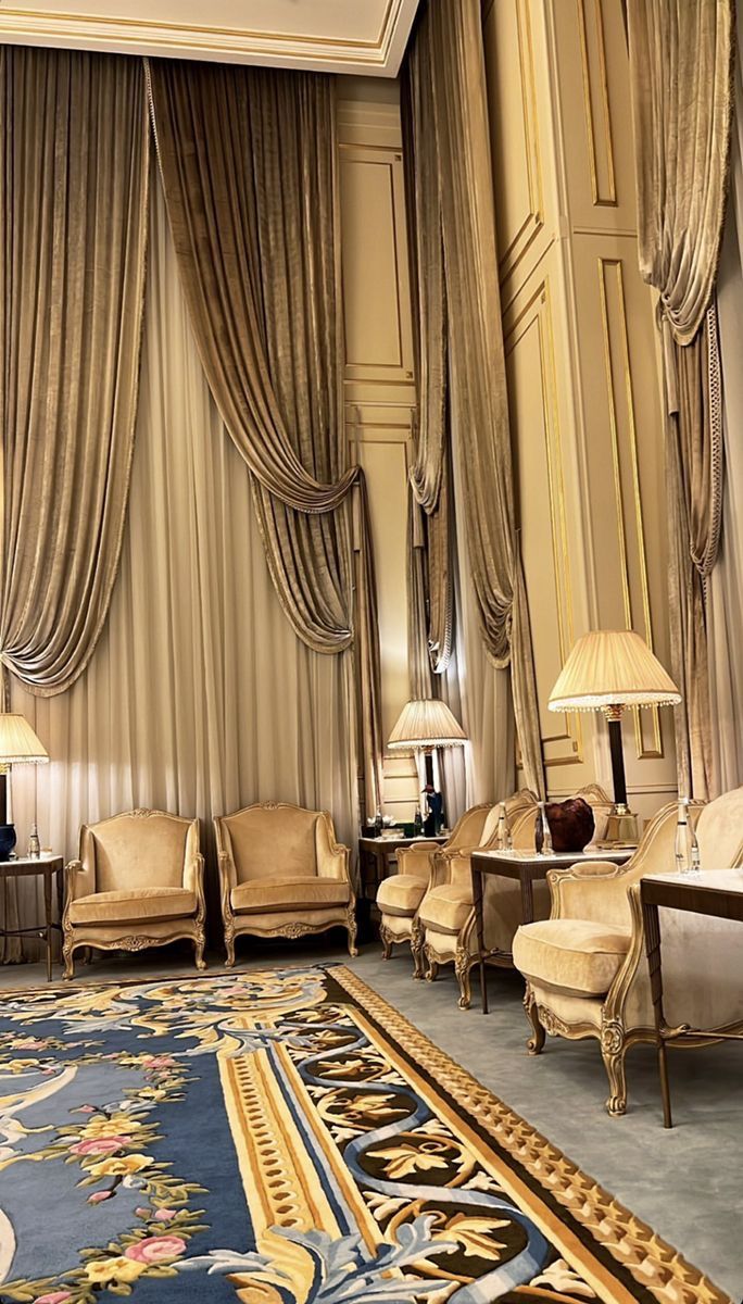 a living room filled with lots of furniture next to a wall covered in drapes