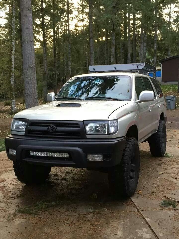 a white truck parked on top of a dirt road