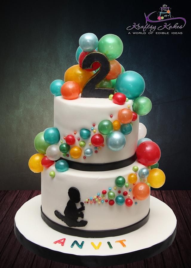 a birthday cake decorated with balloons and the number two on it's tiers