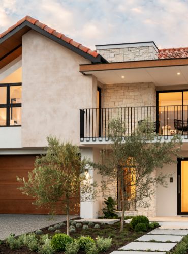 a modern house with stone steps leading up to the front door