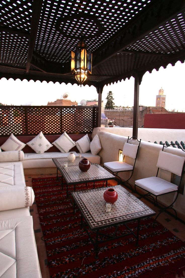 an outdoor living area with couches, tables and rugs on the roof terrace