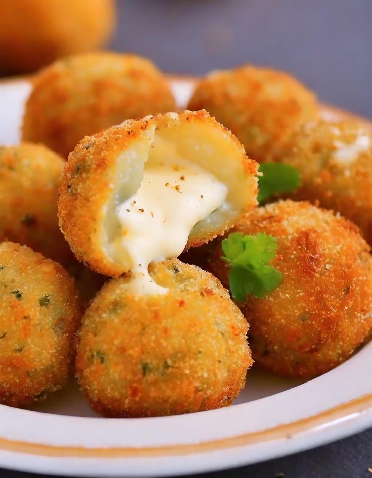 small appetizers with cheese and parmesan on a plate next to oranges