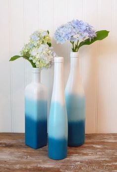 three blue and white vases with flowers in them