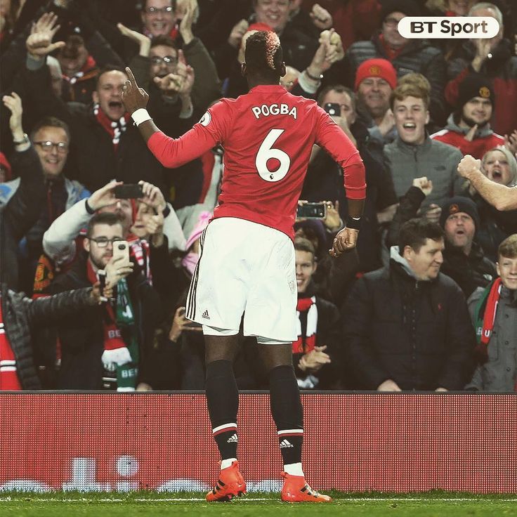 two soccer players are congratulating each other on the field with fans in the background