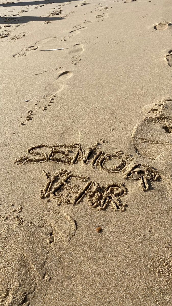 someone wrote some words in the sand at the beach