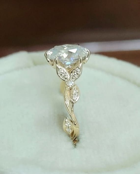 an engagement ring is sitting on top of a white velvet box with a diamond in the center