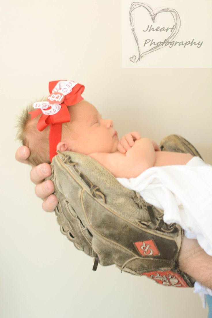 a man holding a baby in a catchers mitt wearing a red headband