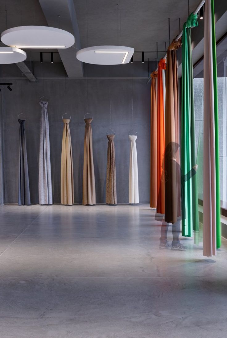 an empty room with several different colored curtains hanging from the ceiling and on the walls