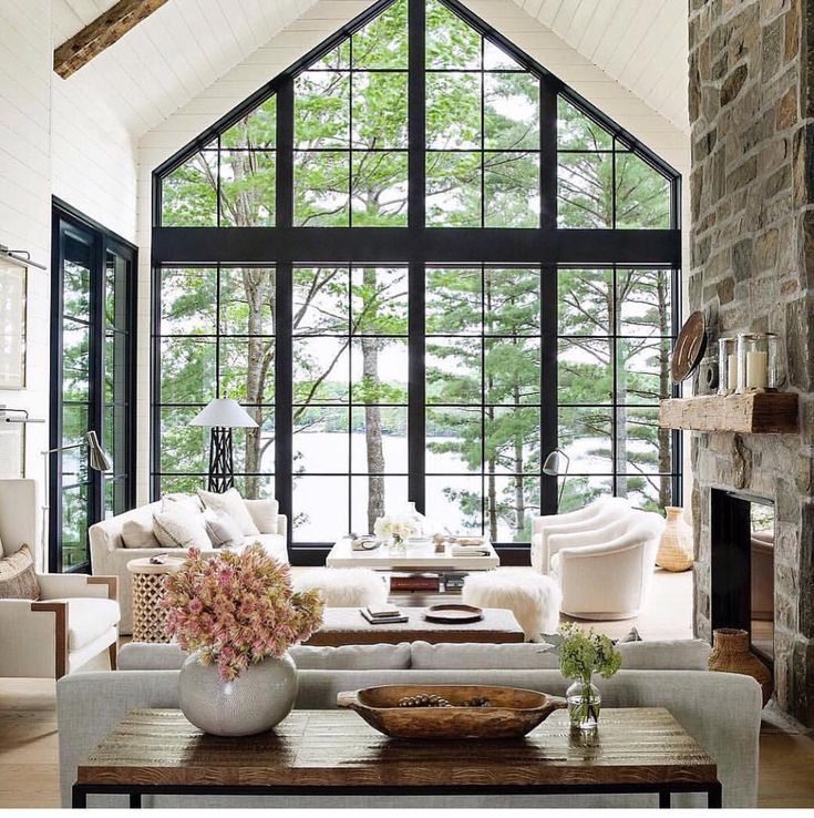 a living room filled with furniture and a large window covered in lots of natural light