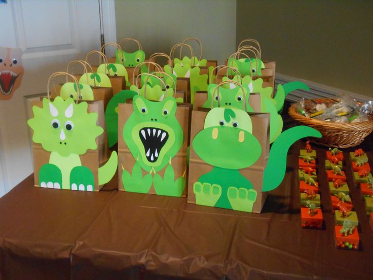 there are many bags on the table with dinosaurs painted on them and one bag has an open mouth