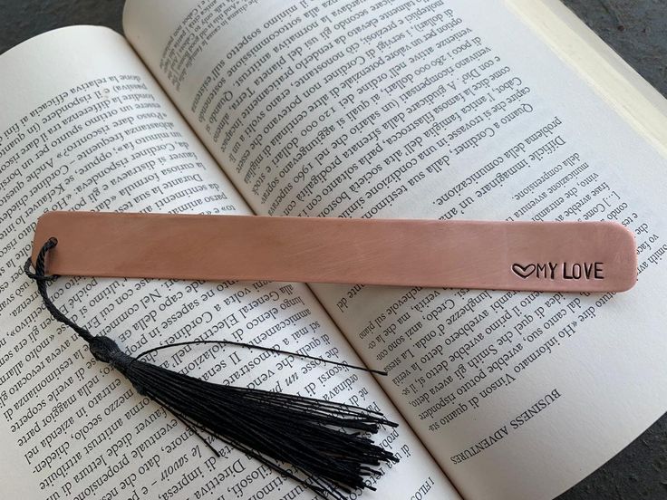 a bookmark with a tassel on top of an open book