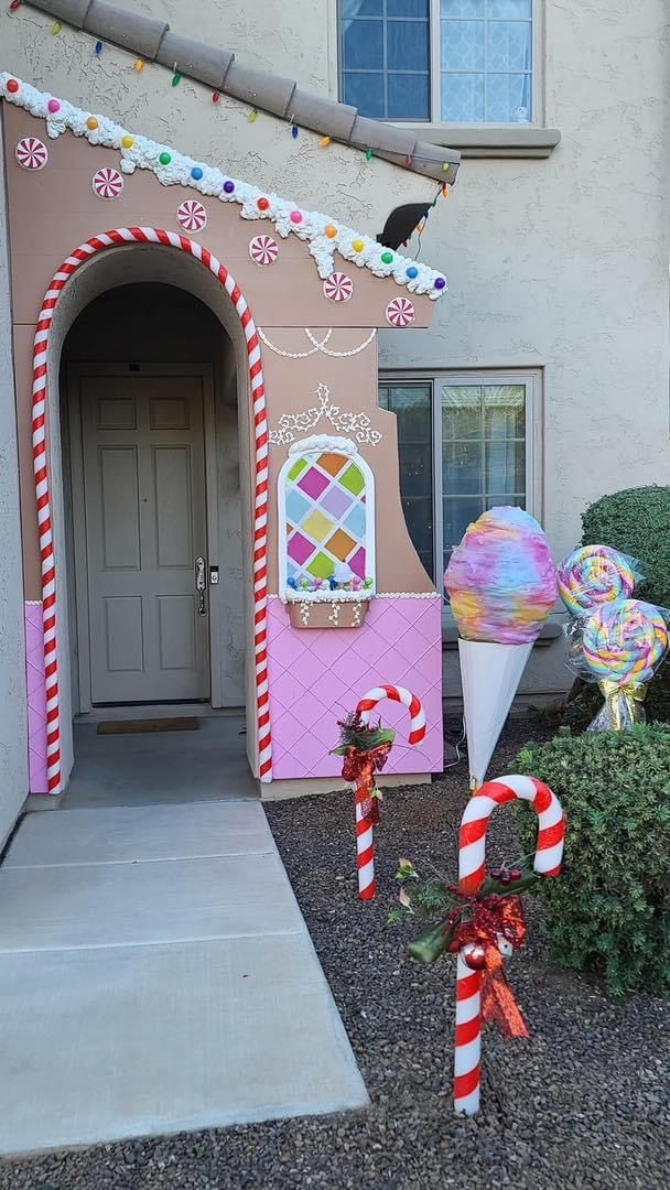 some candy canes are in front of a house with decorations on the door and windows