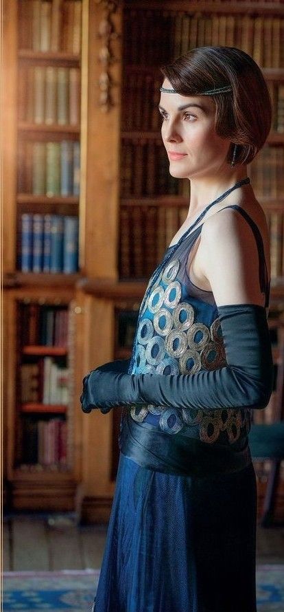 a woman standing in front of a bookshelf with her hands on her hips