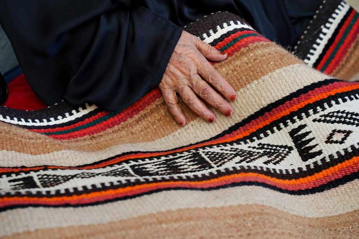 an older person laying on top of a rug with their hands resting on the ground