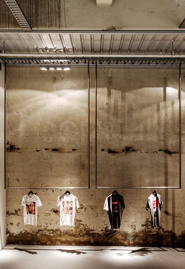 an empty room with three t - shirts hanging on the wall