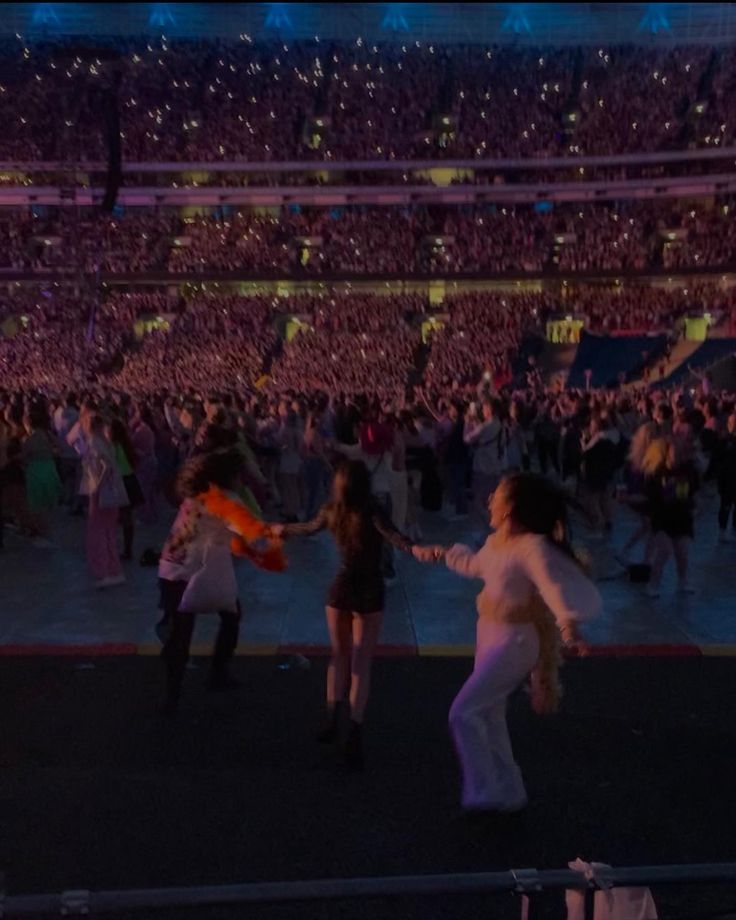 two women dancing in front of an audience at a concert