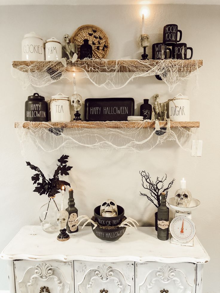 a white dresser topped with shelves filled with halloween decorations