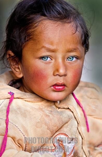 a close up of a child with blue eyes