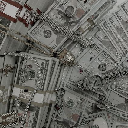 a pile of money sitting on top of a table covered in chains and bracelets