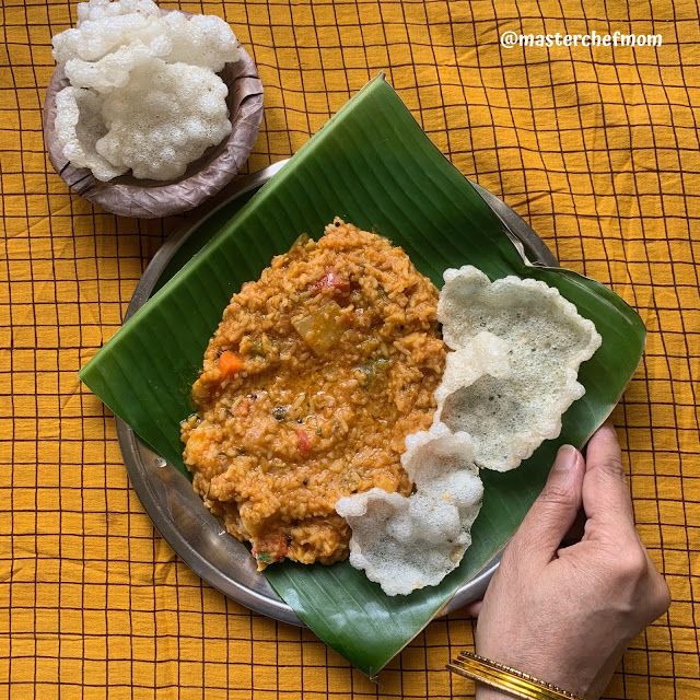 a person holding a plate of food on a yellow table cloth next to another plate