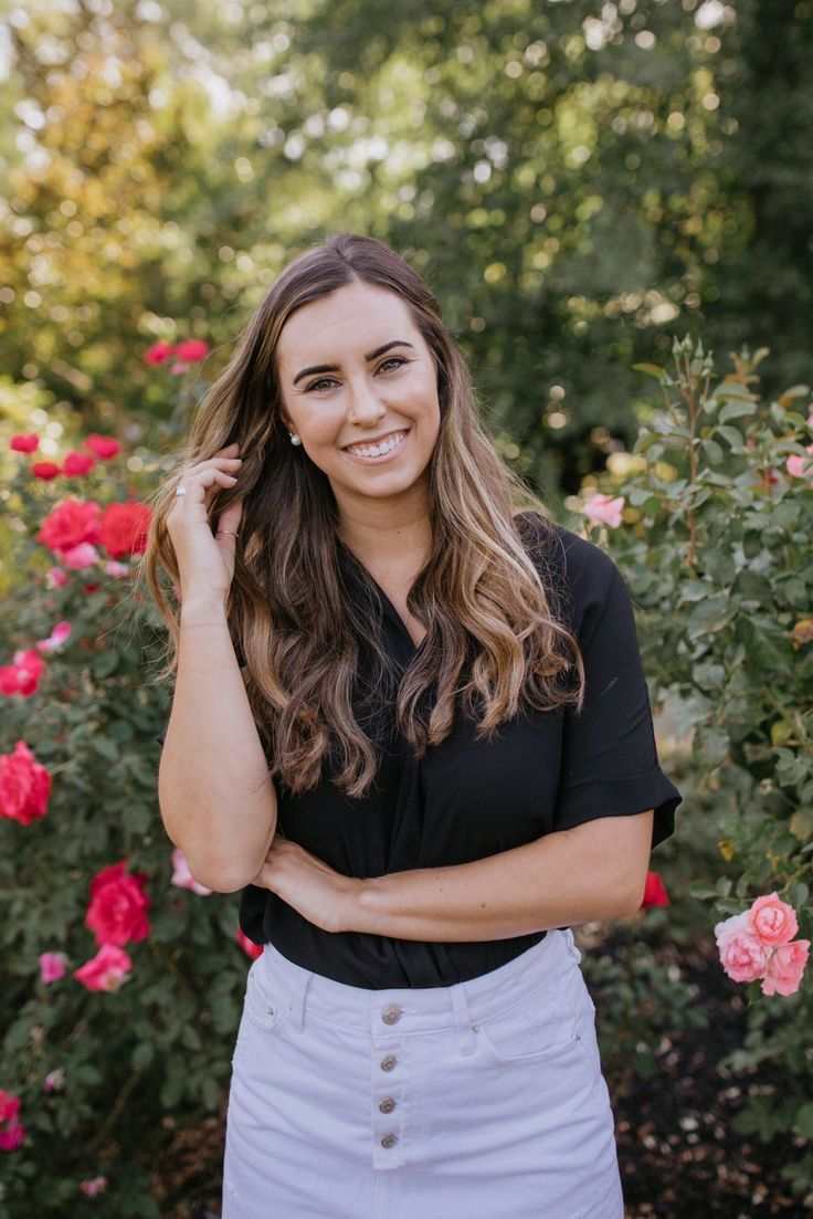 a woman standing in front of some flowers