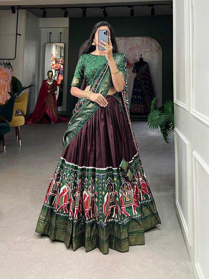 Patola printed lehenga choli with fancy foil work, designer brown lehenga for women, wedding lehenga with dupatta, new Indian chaniya choli Lehenga(Stitched) Color : 1) Brown 2) Navy Blue   Lehenga Fabric : Dola Silk  Lehenga Work : Patola Print and foil work  Lehenga Waist : SUPPORTED UP TO 40 Lehenga Closer : Drawstring With Heavy Tassels and Zip Stitching : Stitched With Canvas and attached with Can Can Length : 40 Flair : 4.50 Meter  Inner : Micro Cotton Blouse(Unstitched) Blouse fabric : Do Navy Blue Lehenga, Zip Stitching, Patola Print, Navratri Garba, Silk Lehenga Choli, Navratri Chaniya Choli, Stitched Lehenga, Work Lehenga, Blue Lehenga