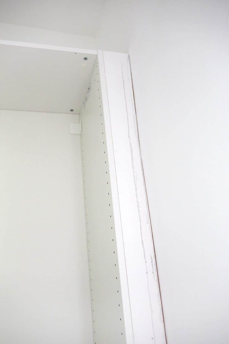 an empty closet with white walls and shelves