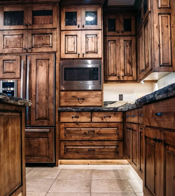 a kitchen with wooden cabinets and granite counter tops in the center, along with an oven