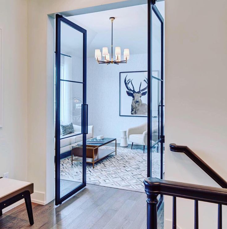 an entry way with glass doors leading to the living room and dining room area in this home