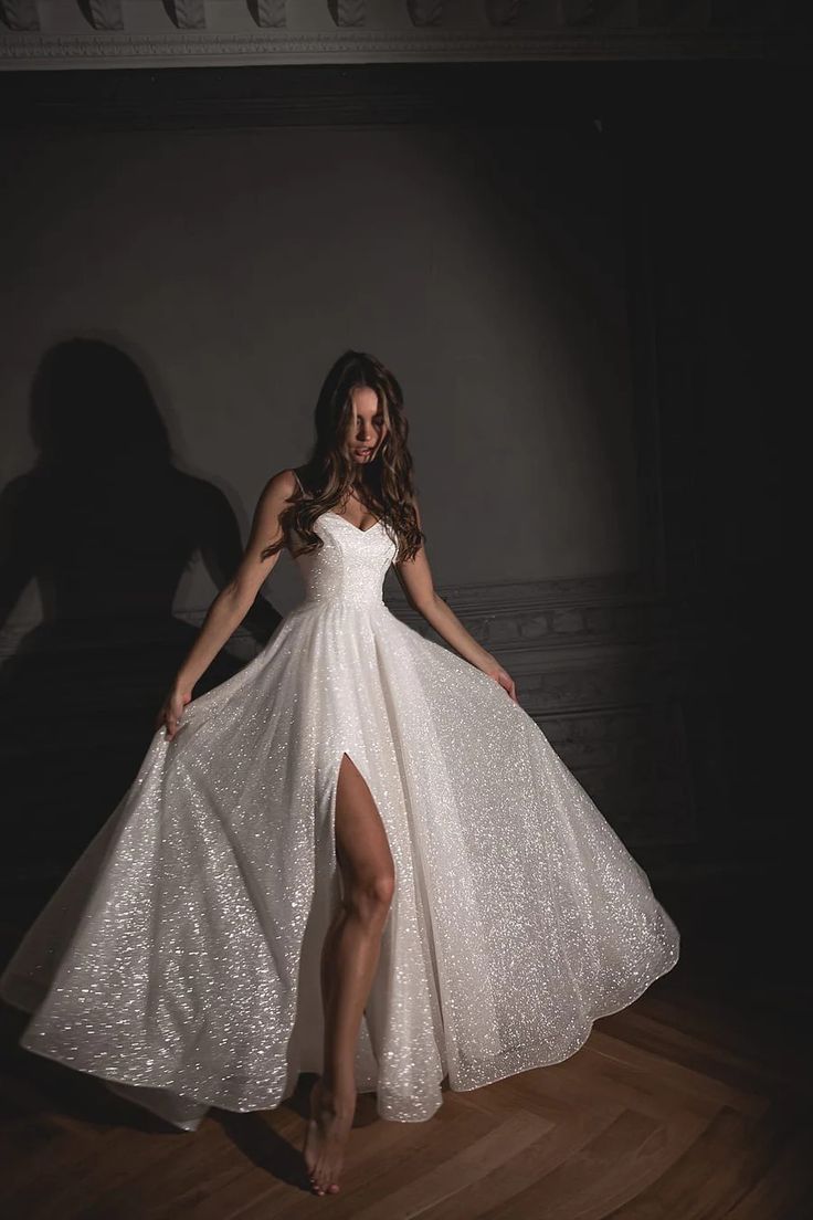 a woman in a white dress standing on a wooden floor