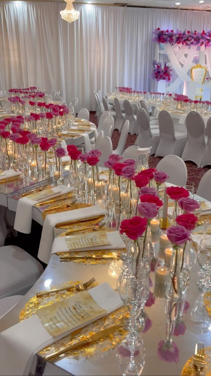 the tables are set with white chairs and pink flowers