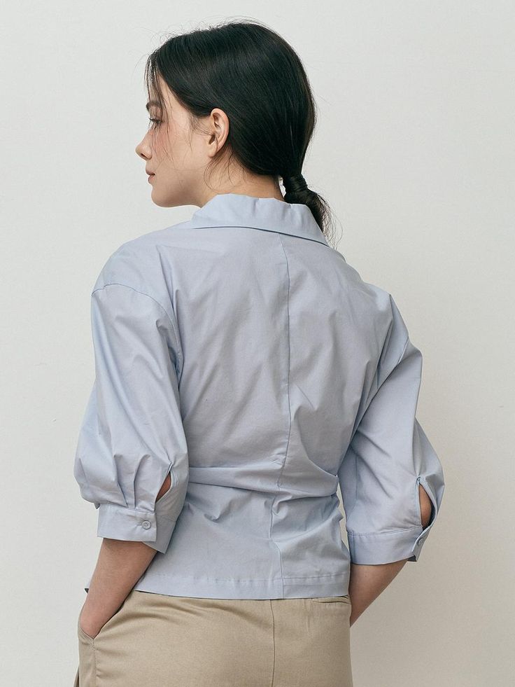 This is We’Dee’s shirt features a clean look with an asymmetrical design that adds a unique touch. The front has two buttons for easy wear and removal, serving as a focal point of the look.- Perfect for daily wear- Can be paired with different styles of bottoms to create various looks- The clean design makes it easy to style with any outfit Modern Spring Shirt With Button Closure, Modern Collared Blouse With Button Closure, Office Button-up Tops With Cuffed Sleeves, Business Casual Button-up Top With Button Cuffs, Business Casual Button-up Tops With Roll-up Sleeves, Business Casual Tops With Roll-up Sleeves And Spread Collar, Office Tops With Button Cuffs And Spread Collar, Business Casual Tops With Roll-up Sleeves And Shirttail Hem, Tops With Button Cuffs And Spread Collar