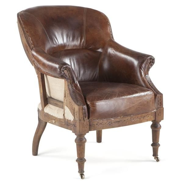 a brown leather chair sitting on top of a white floor next to a wooden frame