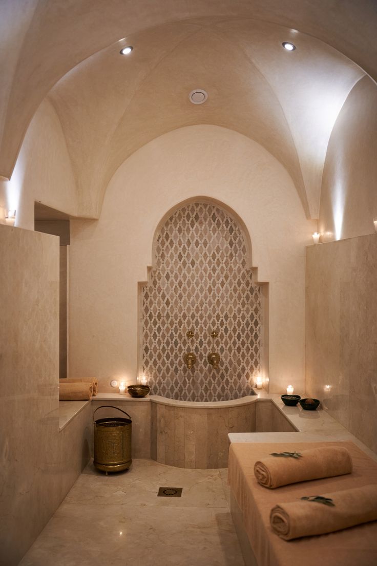 a bath room with a large tub and candles