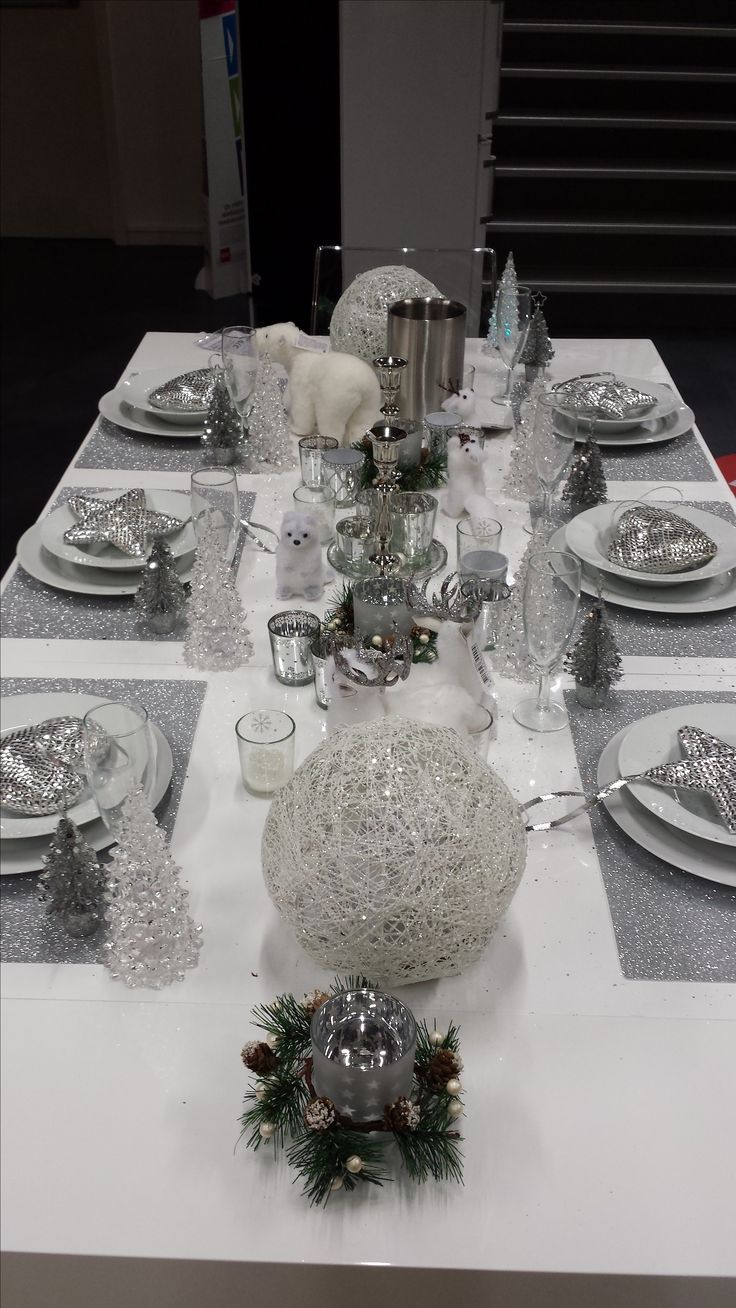 the table is set with silver and white decorations