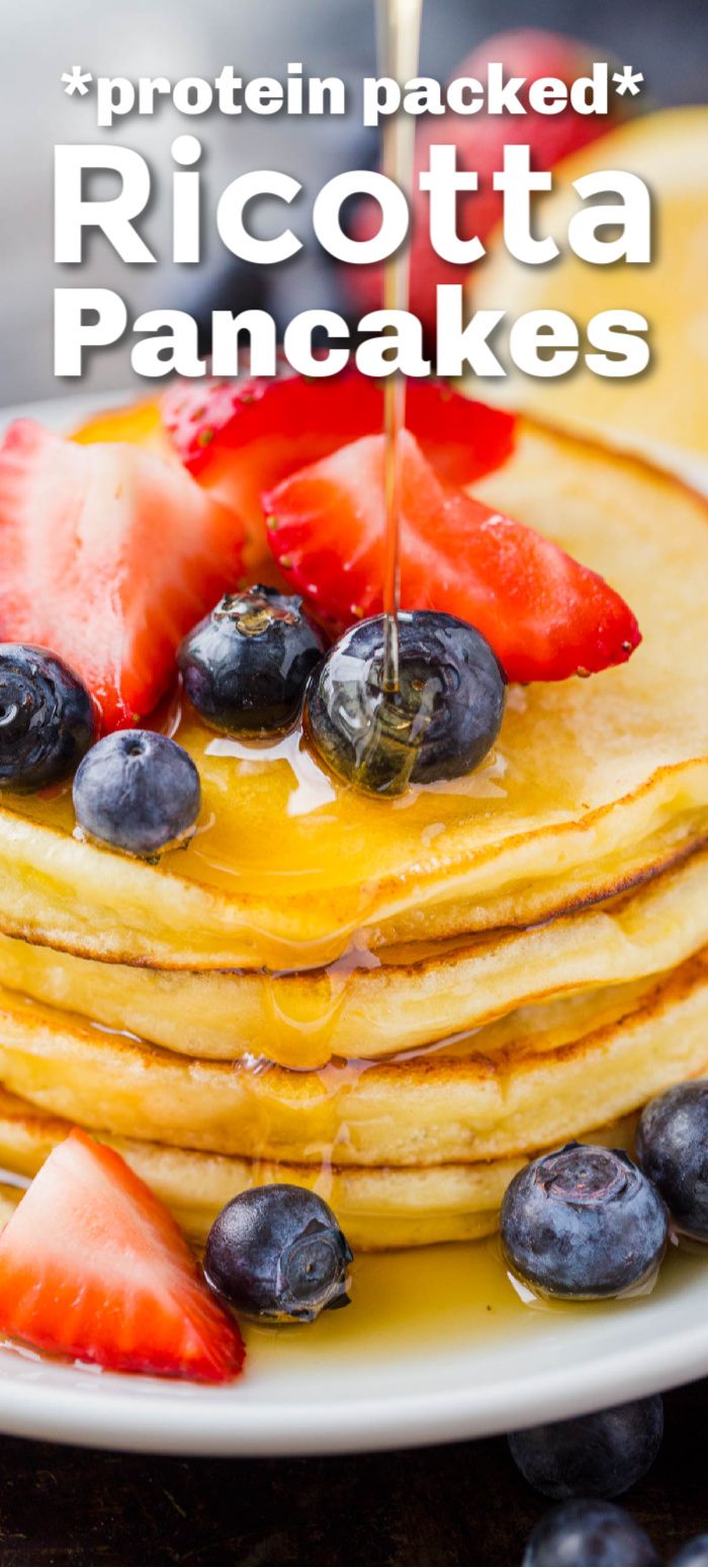 a stack of pancakes with syrup and strawberries on the side that says protein packed ricotta pancakes