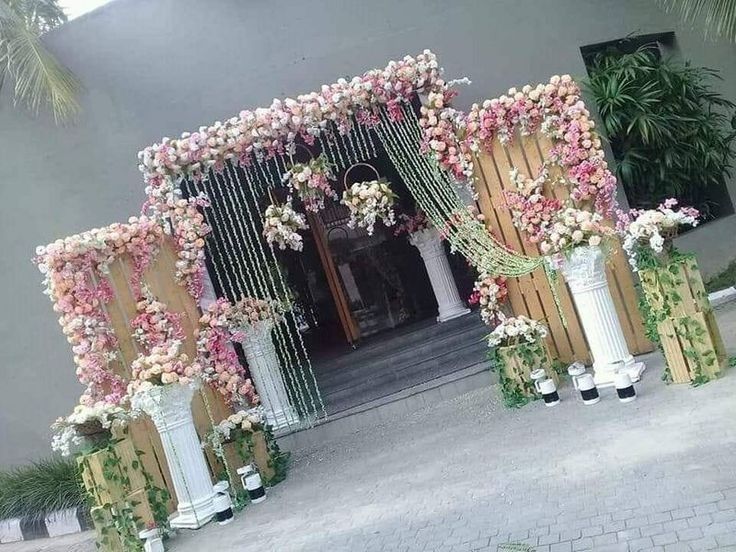 an entrance decorated with flowers and greenery for a wedding or special occasion to be attended