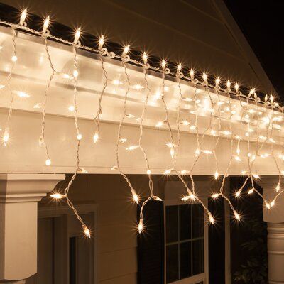 white lights are strung on the outside of a house