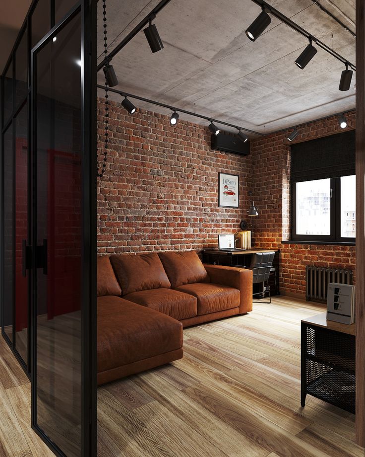 a living room with brick walls and wooden flooring is shown in this image, there are lights hanging from the ceiling